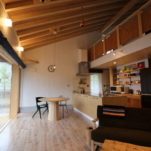 Idées déco pour une petit salle à manger ouverte sur le salon montagne avec un mur blanc, un sol en contreplaqué, un poêle à bois, un manteau de cheminée en lambris de bois, un plafond en poutres apparentes et du lambris de bois.