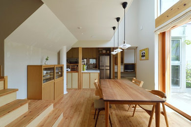 Ispirazione per una sala da pranzo aperta verso il soggiorno etnica di medie dimensioni con pareti bianche, pavimento in legno massello medio e pavimento marrone