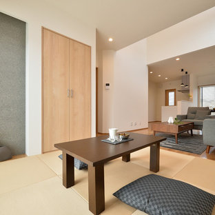 Cette image montre une salle à manger asiatique avec un mur blanc, un sol de tatami et un sol marron.