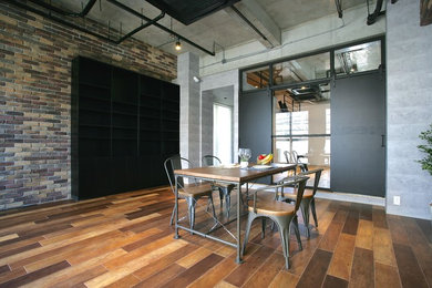 This is an example of an industrial dining room in Other with multi-coloured walls, medium hardwood flooring and brown floors.