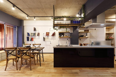 Ispirazione per una grande sala da pranzo aperta verso il soggiorno industriale con pavimento in legno massello medio