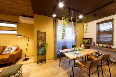 Imagen de comedor urbano pequeño abierto con paredes amarillas, suelo de madera en tonos medios y suelo marrón