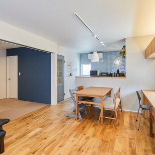 Lantlig inredning av en mellanstor matplats med öppen planlösning, med vita väggar, mellanmörkt trägolv och beiget golv