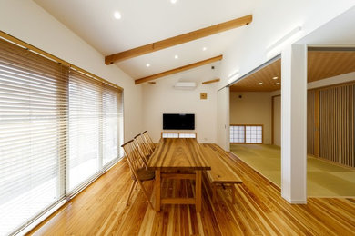 Ejemplo de comedor asiático de tamaño medio con paredes blancas y suelo de madera en tonos medios
