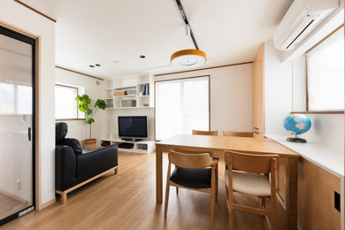 Idées déco pour une petite salle à manger ouverte sur le salon moderne avec un mur blanc, un sol en contreplaqué et un sol beige.