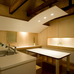 Ispirazione per una piccola sala da pranzo aperta verso il soggiorno moderna con pareti beige, pavimento in compensato, pavimento marrone, travi a vista e pareti in legno