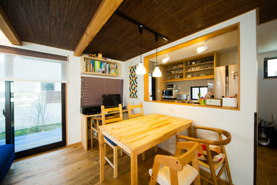 Imagen de comedor asiático con paredes blancas, suelo de madera en tonos medios y suelo marrón