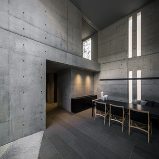 Exemple d'une grand salle à manger industrielle avec un mur gris et un sol gris.