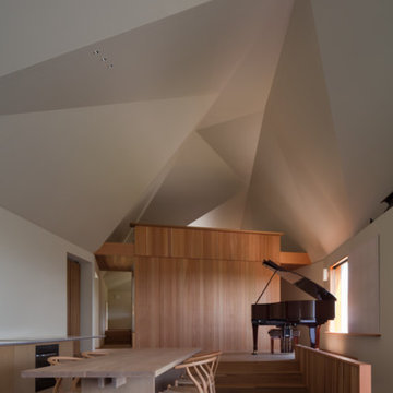 多面体屋根に包まれた主室。ピアノが置かれた450mm高くなった場所がステージのような役割を果たす。　Main room enclosed by polyhedr