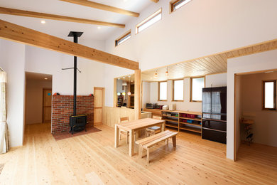 Exempel på en asiatisk matplats med öppen planlösning, med vita väggar, ljust trägolv och brunt golv