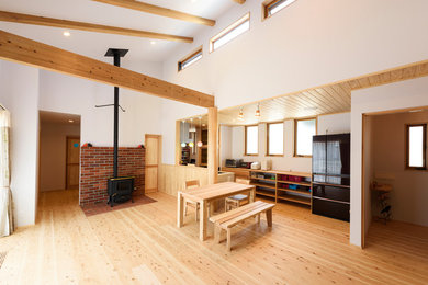 World-inspired open plan dining room in Other with white walls, light hardwood flooring and brown floors.