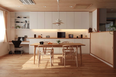 Modelo de comedor de estilo zen abierto con paredes blancas, suelo de madera en tonos medios y suelo marrón