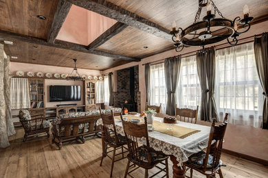 Idee per una sala da pranzo country con pareti rosa, pavimento in legno massello medio e pavimento marrone