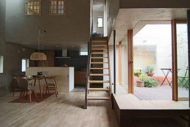 Diseño de comedor urbano de tamaño medio abierto con paredes grises, suelo de madera clara y suelo beige