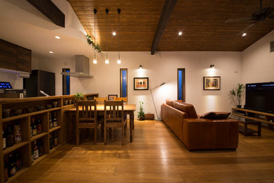 Modelo de comedor de estilo zen abierto con paredes blancas, suelo de madera en tonos medios y suelo marrón