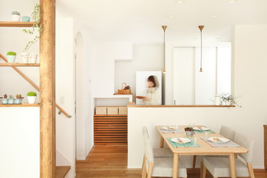 他の地域にある北欧スタイルのおしゃれなダイニングキッチン (白い壁、無垢フローリング、暖炉なし) の写真