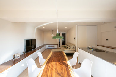 Foto de comedor moderno abierto con paredes blancas, suelo de madera pintada y suelo beige