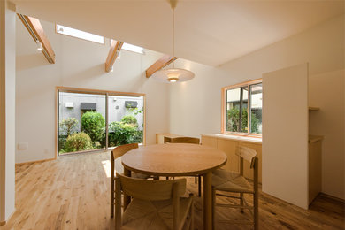 Imagen de comedor de estilo zen con paredes blancas, suelo de madera en tonos medios y suelo marrón