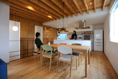 Foto de comedor de estilo americano pequeño abierto sin chimenea con paredes blancas, suelo de madera en tonos medios, suelo marrón, machihembrado y madera