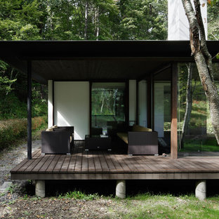 Idee per un patio o portico moderno davanti casa con pedane e un tetto a sbalzo