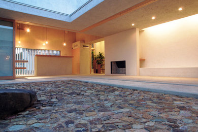 他の地域にある高級な中くらいなミッドセンチュリースタイルのおしゃれな中庭のテラス (天然石敷き、張り出し屋根) の写真