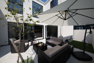 Ejemplo de patio contemporáneo de tamaño medio sin cubierta en patio con cocina exterior y suelo de baldosas