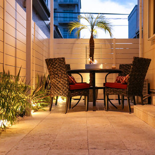 Idee per un patio o portico costiero nel cortile laterale con pavimentazioni in pietra naturale e un parasole