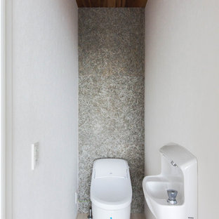 Inspiration för små moderna toaletter, med en bidé, grå väggar, plywoodgolv, ett konsol handfat och beiget golv