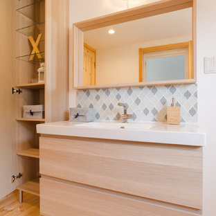 Immagine di un bagno di servizio scandinavo di medie dimensioni con ante lisce, ante in legno chiaro, piastrelle multicolore, piastrelle di vetro, pareti bianche, parquet chiaro, lavabo integrato, top in superficie solida, pavimento beige e top bianco