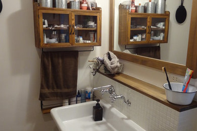 Esempio di un bagno di servizio etnico con piastrelle bianche, piastrelle a mosaico, pareti bianche e lavabo sospeso