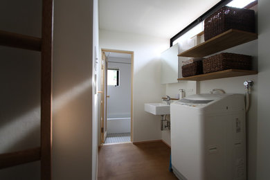 Modelo de aseo moderno pequeño con paredes blancas, lavabo suspendido y encimera de madera