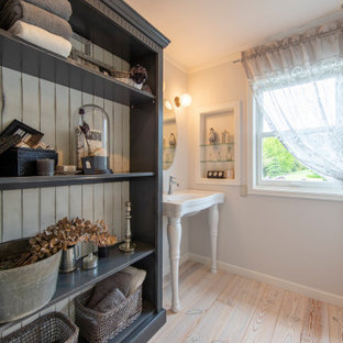 Réalisation d'un WC et toilettes style shabby chic avec un placard sans porte, des portes de placard blanches, un sol en bois clair, une vasque, un plan de toilette en surface solide, un sol beige, un plan de toilette blanc et meuble-lavabo sur pied.