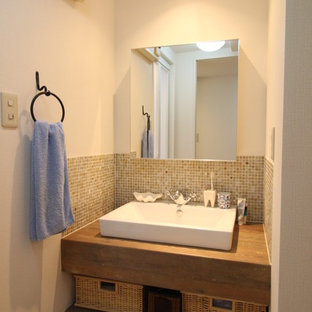 Foto di un bagno di servizio nordico con piastrelle marroni, piastrelle di vetro e lavabo a bacinella