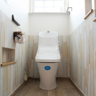 Cette image montre un WC et toilettes marin avec un mur blanc, un sol en bois peint et un sol gris.