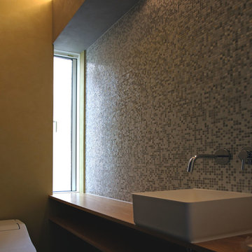 山桜のカウンターと壁に張ったモザイクタイルが美しいトイレ