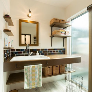 Idées déco pour un WC et toilettes asiatique avec un placard sans porte, un lavabo posé et un sol gris.