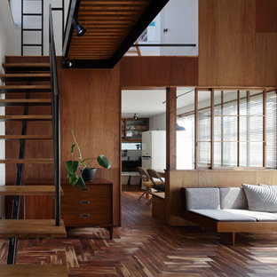 Imagen de sala de estar abierta, de estilo zen, con paredes blancas, suelo de madera oscura y suelo marrón