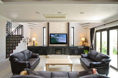 他の地域にあるトランジショナルスタイルのおしゃれなファミリールーム (大理石の床、壁掛け型テレビ、白い床、黒いソファ) の写真