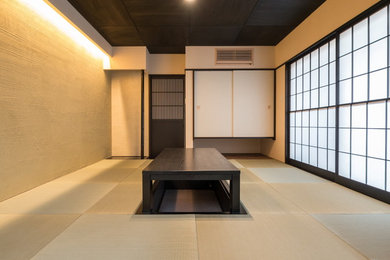 Asiatisk inredning av ett allrum, med beige väggar, tatamigolv och grönt golv