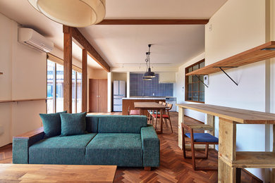 Aménagement d'une salle de séjour contemporaine avec un mur blanc et un sol en bois brun.
