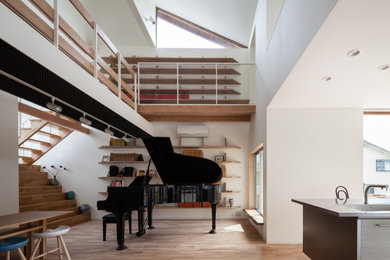 Diseño de sala de estar con rincón musical abierta contemporánea de tamaño medio sin televisor con paredes blancas y suelo de madera en tonos medios