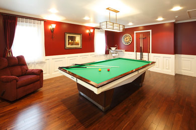 Imagen de sala de estar clásica con paredes rojas, suelo de madera en tonos medios y suelo marrón