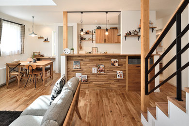 This is an example of a rustic games room in Sapporo with white walls, medium hardwood flooring and brown floors.