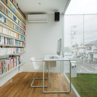 東京23区のモダンスタイルのおしゃれなホームオフィス・書斎 (ライブラリー、白い壁、無垢フローリング、自立型机、茶色い床) の写真