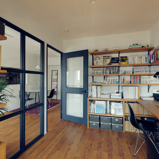 Inspiration för 50 tals hemmabibliotek, med vita väggar, mellanmörkt trägolv och ett inbyggt skrivbord