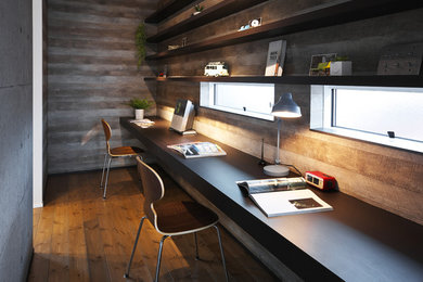 他の地域にあるインダストリアルスタイルのおしゃれなホームオフィス・書斎 (グレーの壁、無垢フローリング、造り付け机) の写真