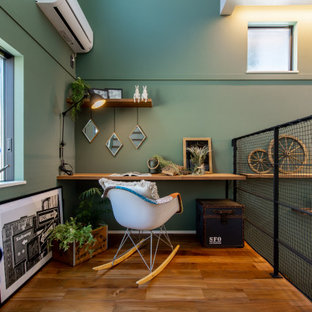 Mittelgroßes Arbeitszimmer mit Arbeitsplatz, grüner Wandfarbe, braunem Holzboden, Einbau-Schreibtisch, Tapetendecke und Tapetenwänden in Sonstige