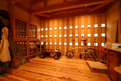 Diseño de estudio de estilo zen pequeño con paredes marrones, suelo de madera en tonos medios y suelo marrón