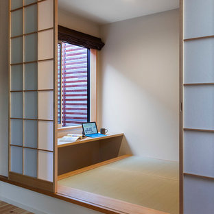 Aménagement d'un bureau moderne avec un mur blanc, un sol de tatami et un bureau intégré.