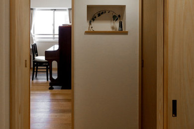 Foto de estudio actual de tamaño medio sin chimenea con paredes blancas, suelo de madera en tonos medios y suelo marrón